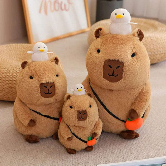 3 peluches capybaras avec un petit oiseau sur la tête