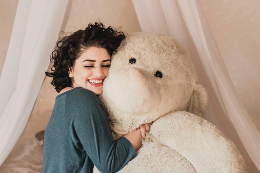 Jeune femme qui serre un gros ourson dans ses bras