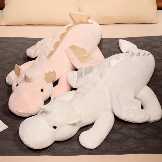 2 peluches dragon licorne sur un lit