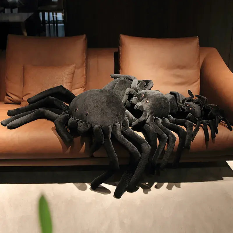 3 peluches araignées sur un canapé
