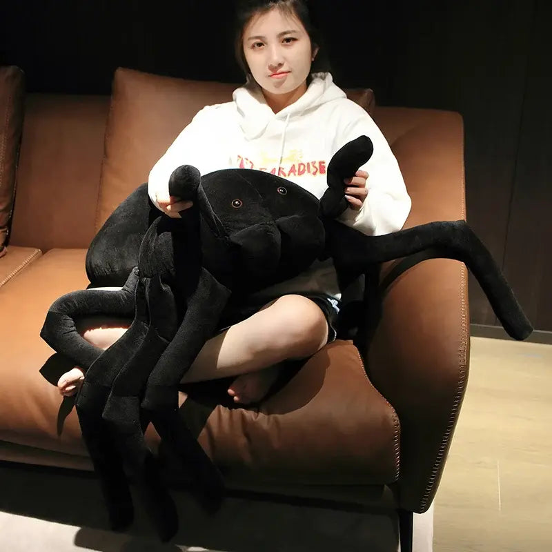 grande peluche araignée noire dans les bras d'une femme