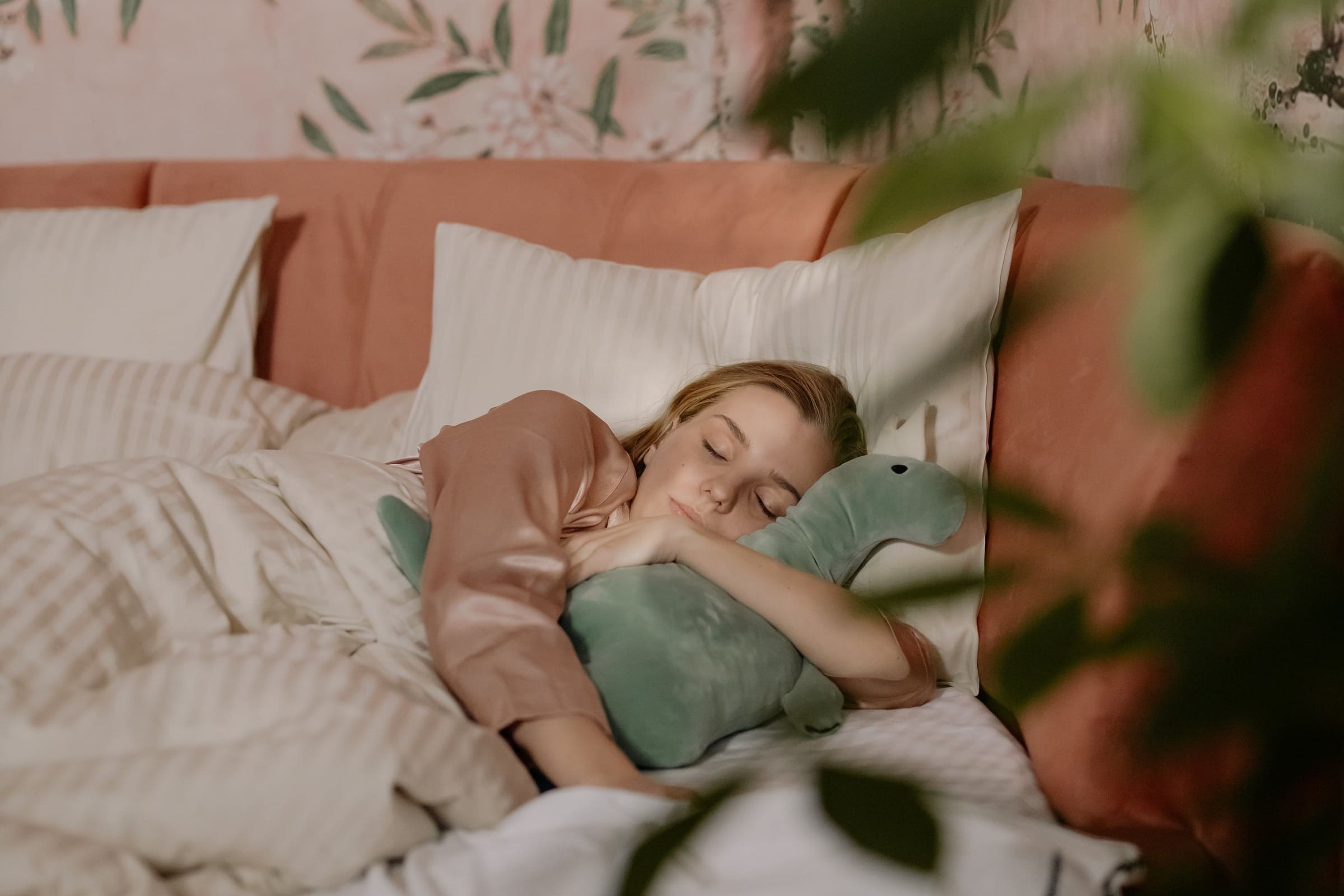 femme endormie avec une grande peluche dinosaure