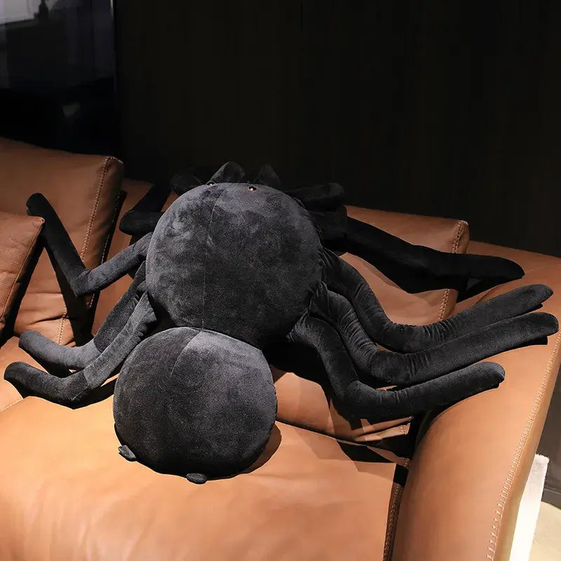 grande peluche araignée noire sur un canapé