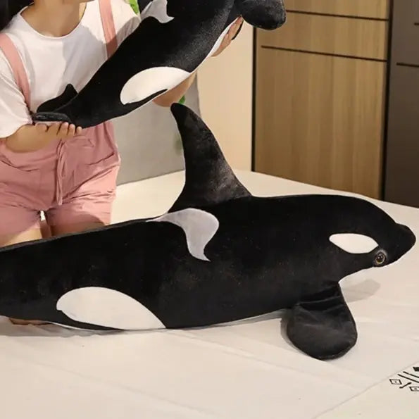 grande peluche orque sur un lit