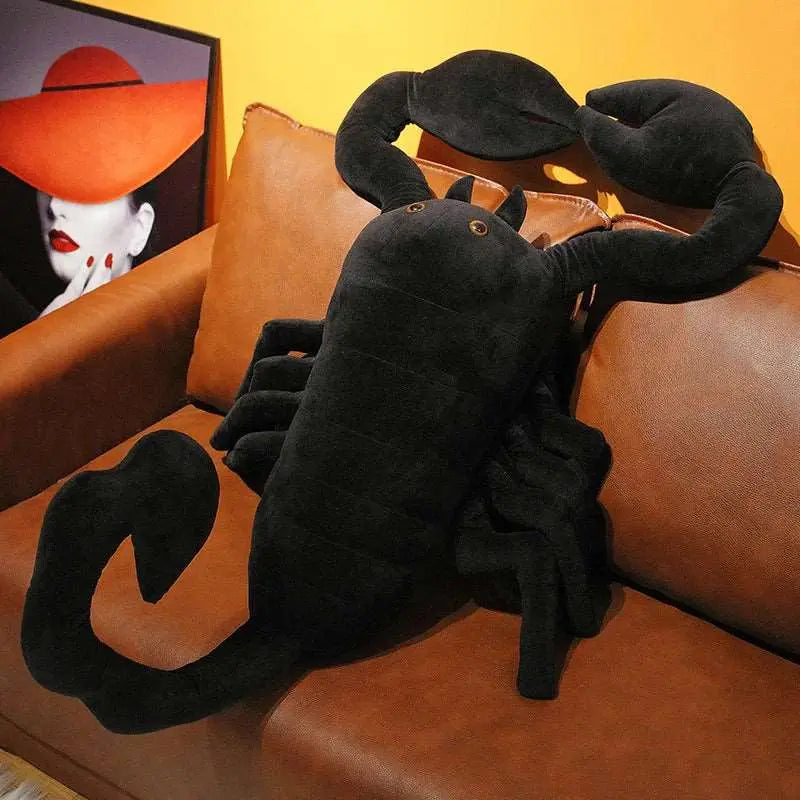 peluche scorpion noir sur un canapé